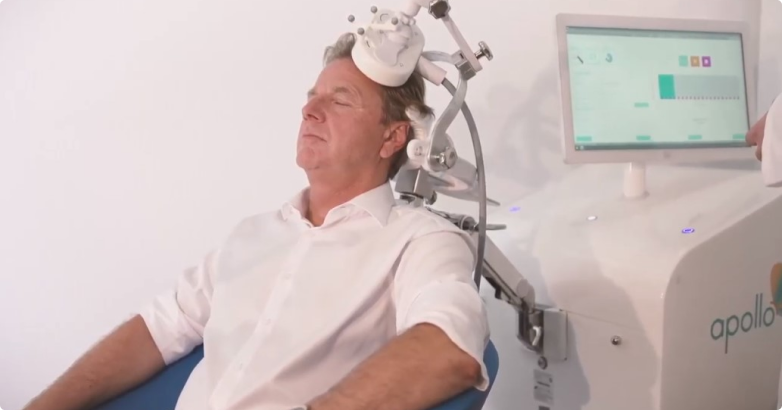 A man is taking Transcranial Magnetic Stimulation Therapy from a machine
